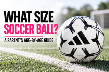 White and black Adidas soccer ball on a soccer field for a guide to choosing the right soccer ball size for kids by age.