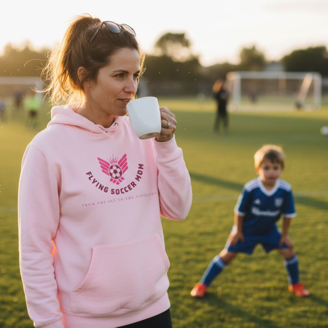 Flying Soccer Mom Hoodie Pink on soccer field
