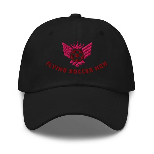 Soccer mom wearing a black cap with pink text and logo, standing outdoors.