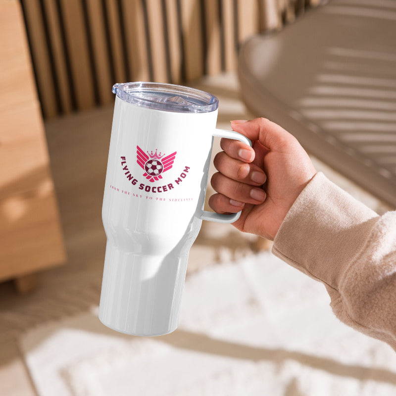 Hand holding a Flying Soccer Mom stainless steel tumbler with handle, perfect for busy mornings and game days.