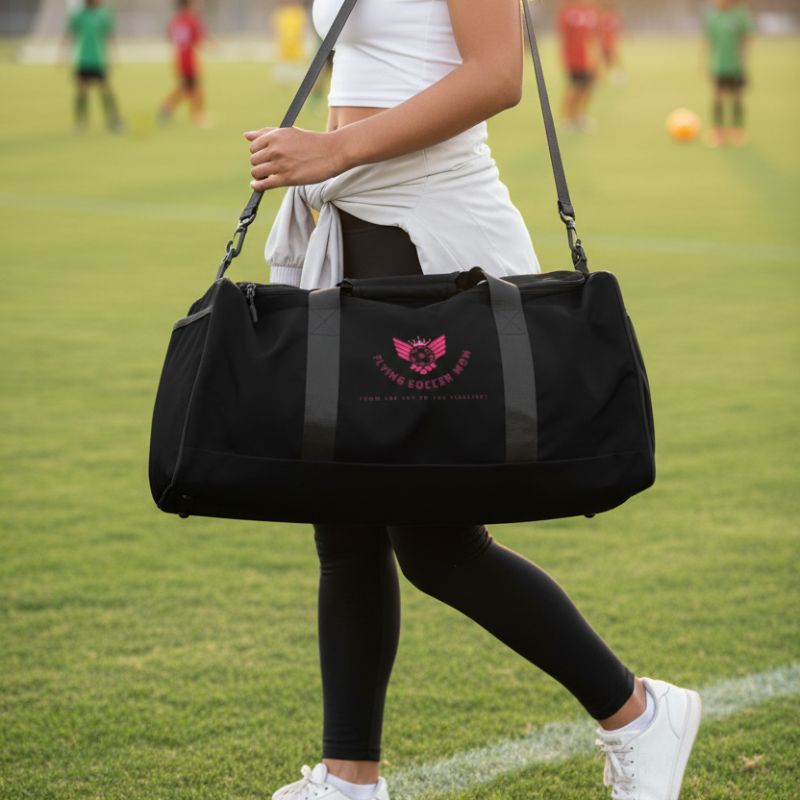 Soccer mom carrying a black soccer mom duffel bag in the soccer field