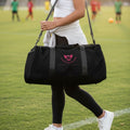Soccer mom carrying a black soccer mom duffel bag in the soccer field
