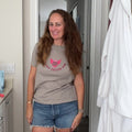 Woman wearing the Flying Soccer Mom relaxed fit tee in heather stone with denim shorts, showing the fit
